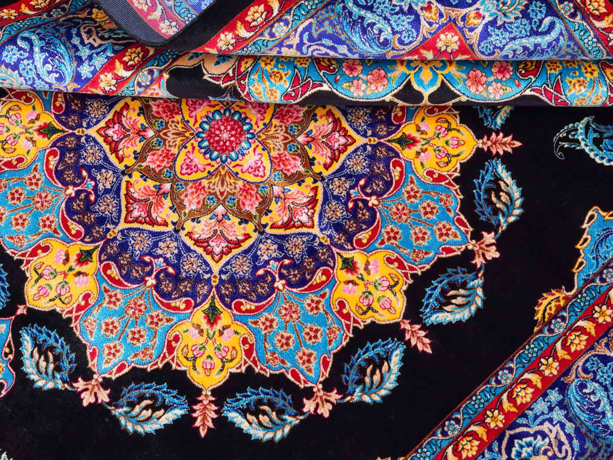 Ghom Maschinenteppich "Tahmina" 150 x 100 cm, mit Spiegel-Medaillon, aus pflanzlicher Seide (Viskose), Schwarz-Blau. Teppichnummer: V87BK150H. Persian Luxury Collection by Khademi. Made in Iran / Persia – Vertrieb durch JUPITER Intl.