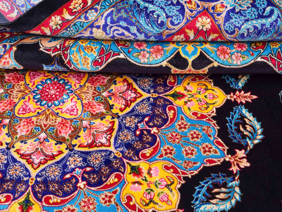 Ghom Maschinenteppich "Tahmina" 150 x 100 cm, mit Spiegel-Medaillon, aus pflanzlicher Seide (Viskose), Schwarz-Blau. Teppichnummer: V87BK150H. Persian Luxury Collection by Khademi. Made in Iran / Persia – Vertrieb durch JUPITER Intl.