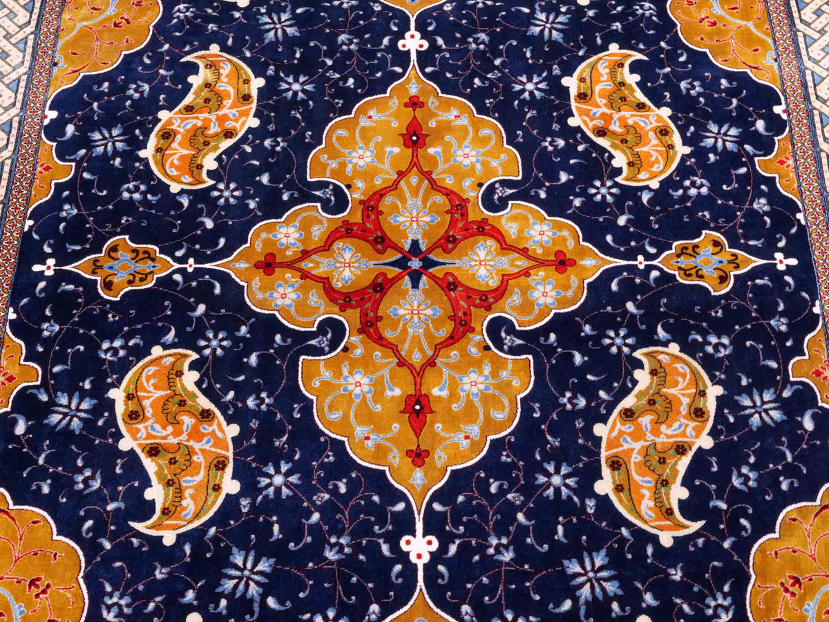 Ghom Maschinenteppich "Tahmuras" 150 x 100 cm, mit Medaillon, aus pflanzlicher Seide (Viskose), Marineblau. Teppichnummer: V88NY150H. Persian Luxury Collection by Khademi. Made in Iran / Persia – Vertrieb durch JUPITER Intl.