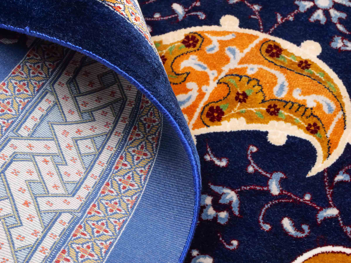 Ghom Maschinenteppich "Tahmuras" 150 x 100 cm, mit Medaillon, aus pflanzlicher Seide (Viskose), Marineblau. Teppichnummer: V88NY150H. Persian Luxury Collection by Khademi. Made in Iran / Persia – Vertrieb durch JUPITER Intl.