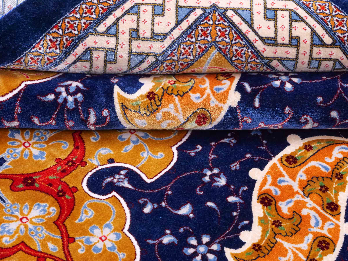 Ghom Maschinenteppich "Tahmuras" 150 x 100 cm, mit Medaillon, aus pflanzlicher Seide (Viskose), Marineblau. Teppichnummer: V88NY150H. Persian Luxury Collection by Khademi. Made in Iran / Persia – Vertrieb durch JUPITER Intl.