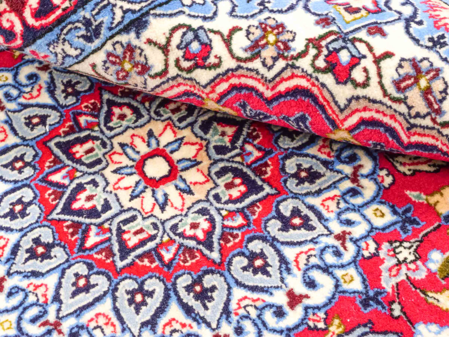 Handgeknüpfter Isfahan Perserteppich von Khademi aus Wolle mit Seide, rot-blau. Feiner, persischer Teppich mit Medaillon. Orientteppich, geknüpft in Iran. Größe: 102 x 72 cm. Teppichnummer: SB3-1097 | Jupiter Intl