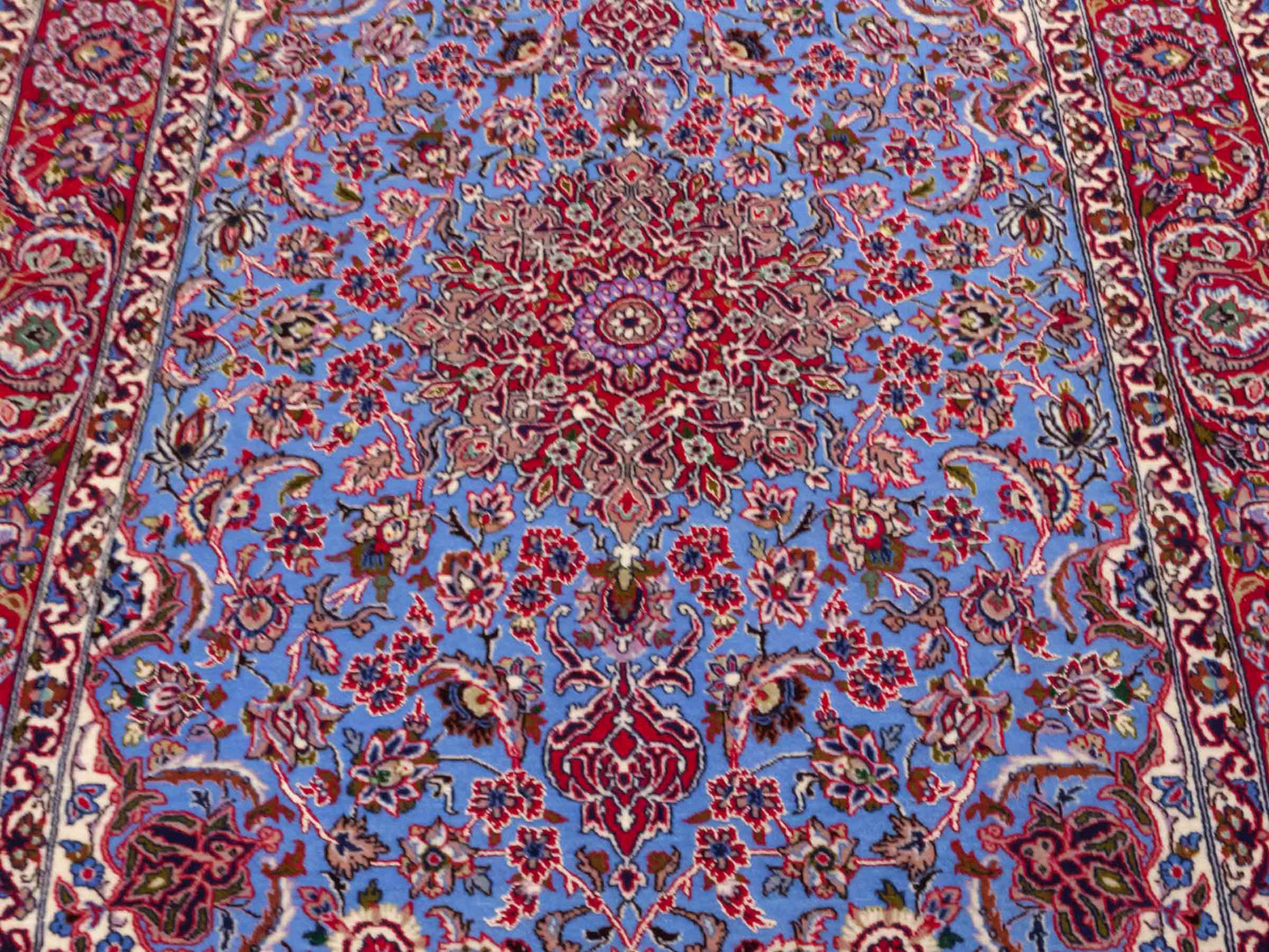 Handgeknüpfter Isfahan Perserteppich von Khademi aus Wolle mit Seide, blau, rot. Feiner, persischer Teppich mit Medaillon. Orientteppich, von Hand geknüpft in Iran. Größe: 171 x 113 cm. Teppichnummer: DB3-1051. Verkauf durch Jupiter Intl.
