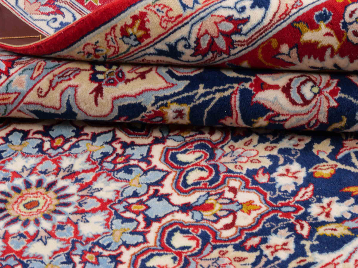 Handgeknüpfter Isfahan Perserteppich von Khademi aus Wolle mit Seide, blau-rot. Feiner, persischer Teppich mit Medaillon. Orientteppich, geknüpft in Iran. Größe: 236 x 152 cm. Teppichnummer: SB3-1082 | Jupiter In