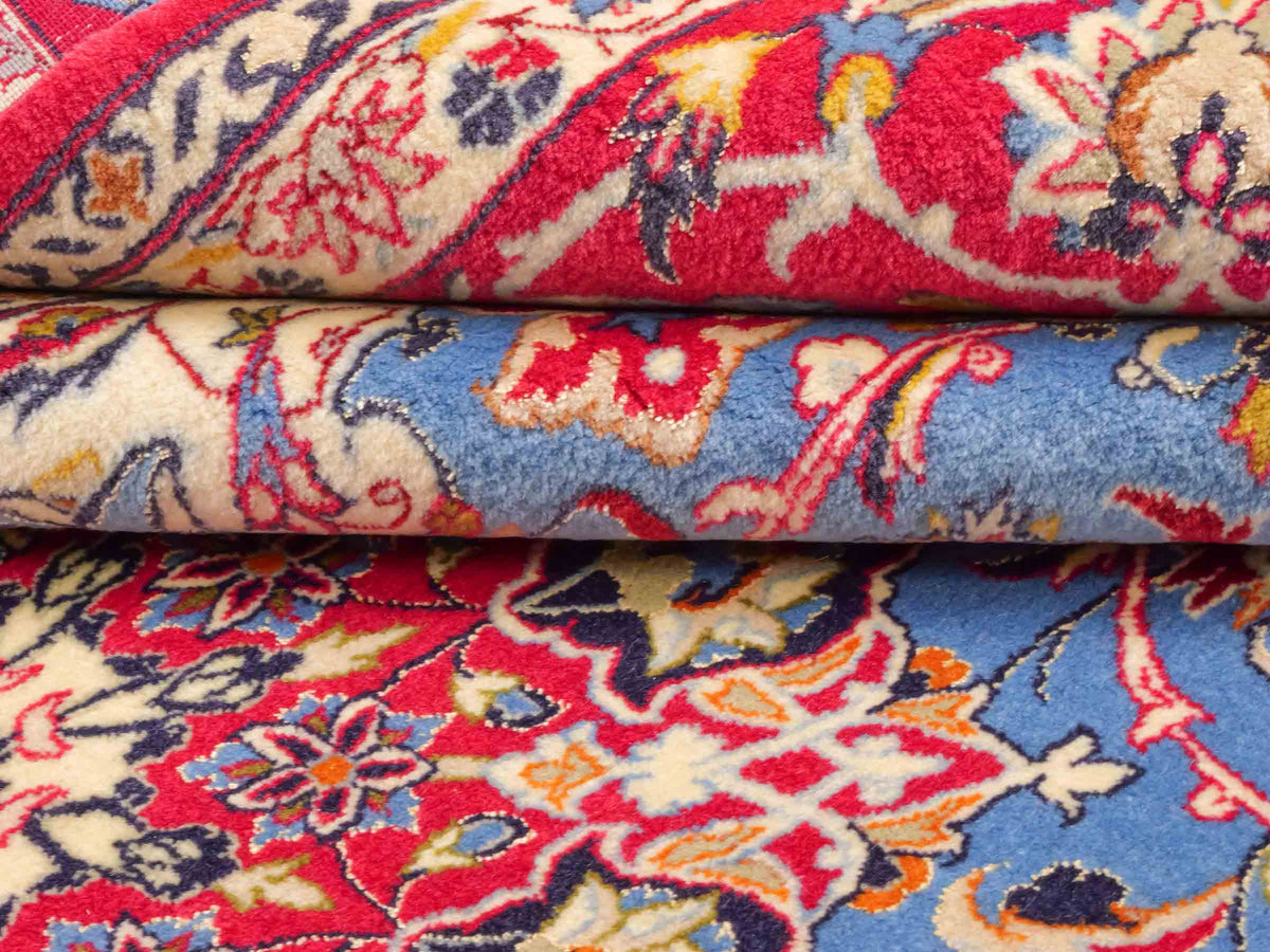 Handgeknüpfter "Tavus" Isfahan Perserteppich von Khademi aus Wolle mit Seide, rot-blau. Feiner, persischer Teppich mit Medaillon, signiert. Orientteppich, geknüpft in Iran. Größe: 247 x 158 cm. Teppichnummer: SB3-1079 | Jupiter In