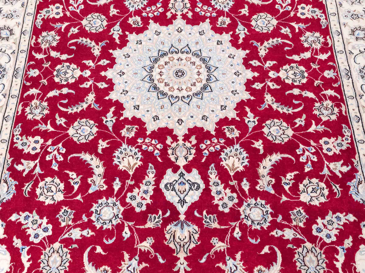 Handgeknüpfter Nain 9La Perserteppich von Khademi aus Wolle mit Seide, signiert, rot-elfenbein-weiß. Persischer Orientteppich mit Medaillon. Von Hand geknüpft in Iran / Persien. Größe: 203 cm x 140 cm. Teppichnummer: SB3-1110 | Jupiter Intl.