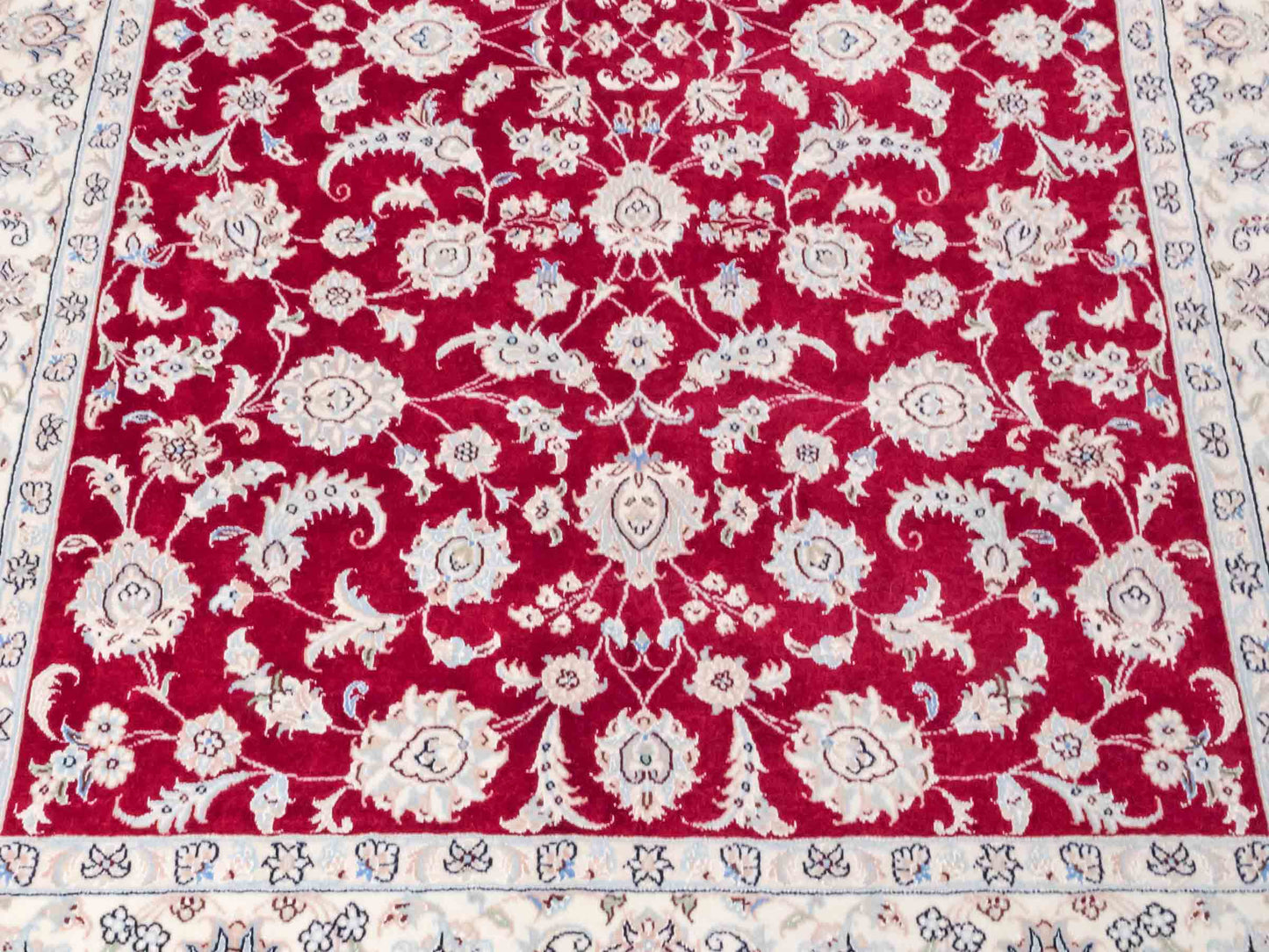 Handgeknüpfter Nain 9La Perserteppich von Khademi aus Wolle mit Seide, signiert, rot-elfenbein-weiß. Persischer Orientteppich mit Allover-Motiv. Von Hand geknüpft in Iran / Persien. Größe: 205 x 136 cm. Teppichnummer: SB3-1087 | Jupiter Intl.