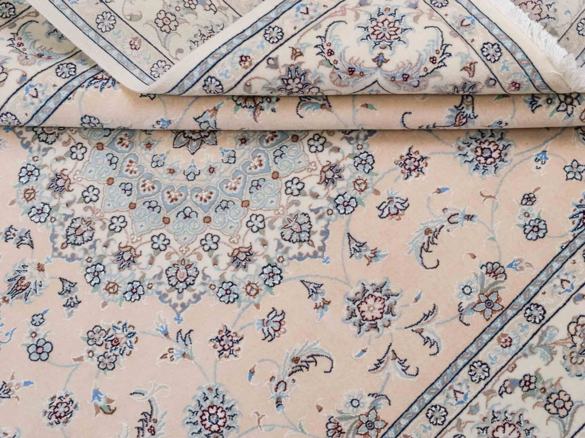 Handgeknüpfter Nain 9La Perserteppich von Khademi aus Wolle mit Seide, signiert, cremeweiß-elfenbein. Persischer Orientteppich mit Medaillon. Von Hand geknüpft in Iran / Persien. Größe: 243 cm x 165 cm. Teppichnummer: SB3-1086 | Jupiter Intl.