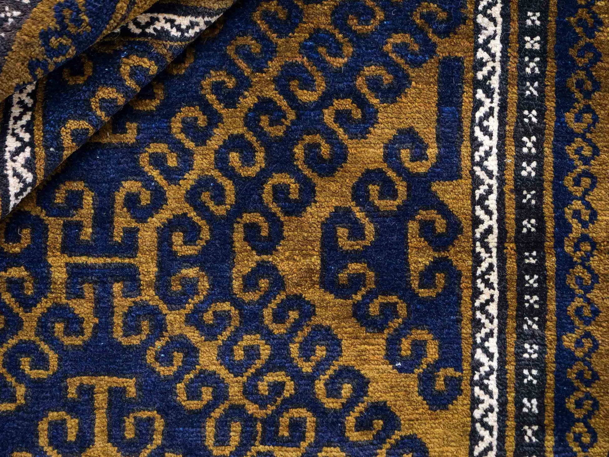 Antiker, handgeknüpfter, afghanischer Belutsch Nomadenteppich aus Wolle von Khademi. Größe: 136 x 80 cm. Farbe: Blau, gold. Verkauf durch JUPITER Intl.