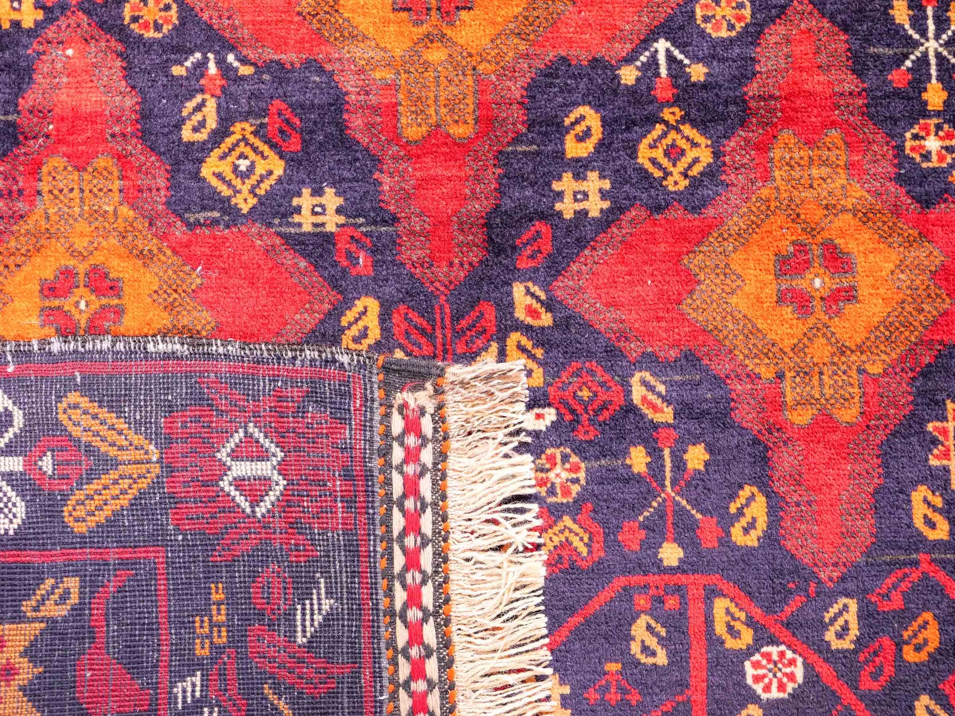 Handgeknüpfter, afghanischer Belutsch Nomadenteppich aus Wolle von Khademi. Größe: 172 x 100 cm. Farbe: Rot, orange, blau. Verkauf durch JUPITER Intl.