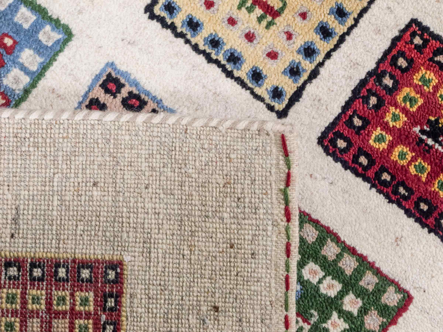 Handgeknüpfter Indo Loribaft Orientteppich von Khademi aus Wolle, cremeweiß, mehrfarbig. Geometrisches Nomaden-Feldmuster. Von Hand geknüpft in Indien. Größe: 92x60cm. Teppichnummer: KB4-1725. Verkauf durch Jupiter Intl.