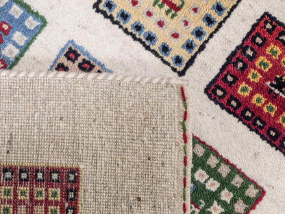 Handgeknüpfter Indo Loribaft Orientteppich von Khademi aus Wolle, cremeweiß, mehrfarbig. Geometrisches Nomaden-Feldmuster. Von Hand geknüpft in Indien. Größe: 92x60cm. Teppichnummer: KB4-1725. Verkauf durch Jupiter Intl.