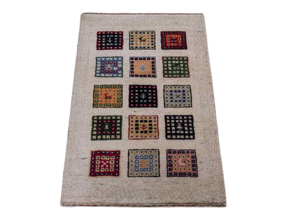 Handgeknüpfter Indo Loribaft Orientteppich von Khademi aus Wolle, cremeweiß, mehrfarbig. Geometrisches Nomaden-Feldmuster. Von Hand geknüpft in Indien. Größe: 92x60cm. Teppichnummer: KB4-1725. Verkauf durch Jupiter Intl.