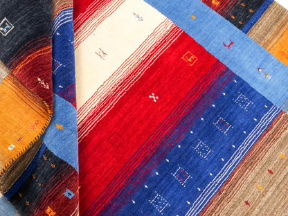 Moderner, Handloom Lori Gabbeh Orientteppich von Khademi aus Wolle, blau, navy, mehrfarbig. Geometrisches Nomaden-Design. Produziert in Indien. Größe: 244x175cm. Teppichnummer: KB4-1817. Verkauf durch Jupiter Intl.