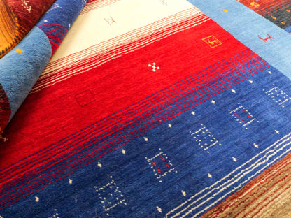 Moderner, Handloom Lori Gabbeh Orientteppich von Khademi aus Wolle, blau, navy, mehrfarbig. Geometrisches Nomaden-Design. Produziert in Indien. Größe: 244x175cm. Teppichnummer: KB4-1817. Verkauf durch Jupiter Intl.