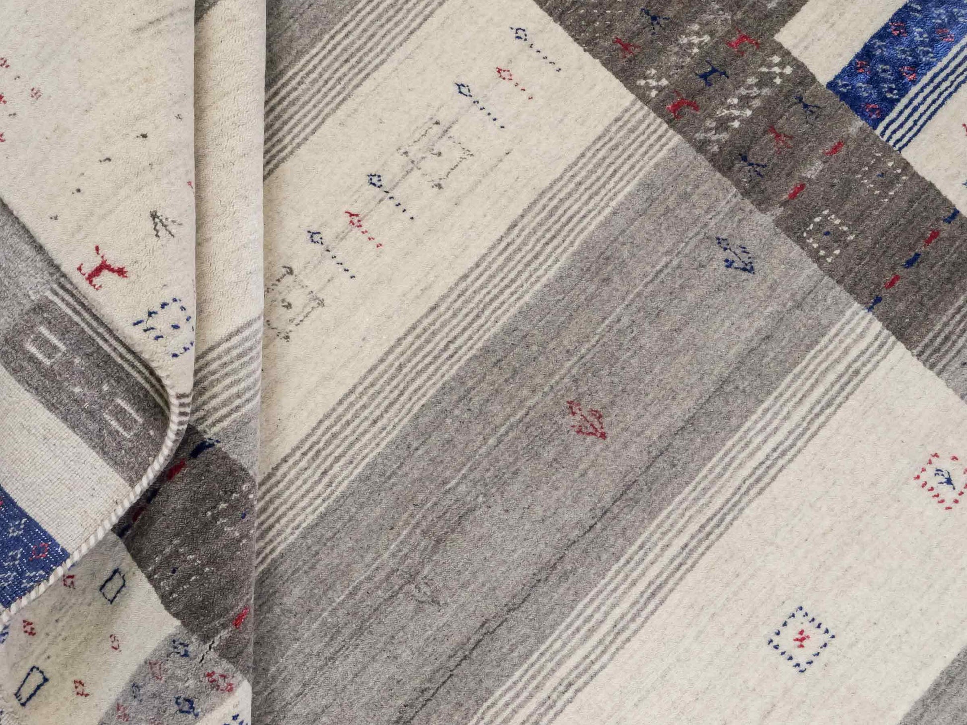 Moderner, Handloom Lori Gabbeh Orientteppich von Khademi aus Wolle mit Bambusseide, cremeweiß, grau, blau, rot. Nomaden-Design. Produziert in Indien. Größe: 239x168cm. Teppichnummer: KB4-1806. Verkauf durch Jupiter Intl.