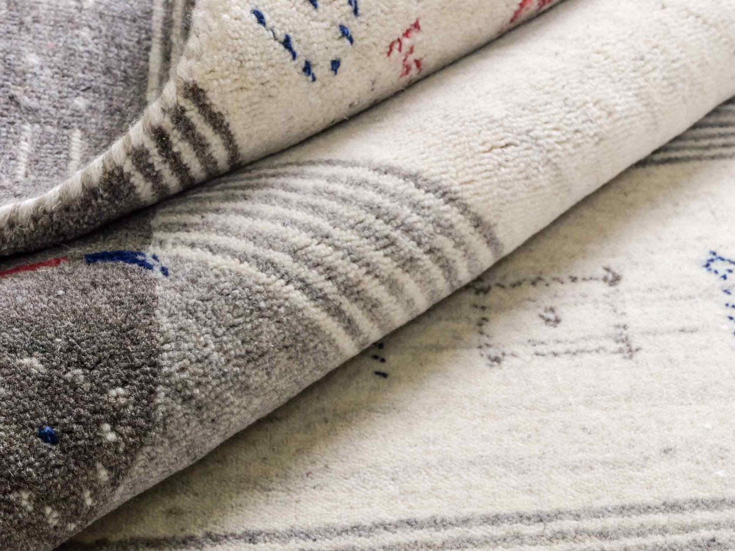 Moderner, Handloom Lori Gabbeh Orientteppich von Khademi aus Wolle mit Bambusseide, cremeweiß, grau, blau, rot. Nomaden-Design. Produziert in Indien. Größe: 239x168cm. Teppichnummer: KB4-1806. Verkauf durch Jupiter Intl.