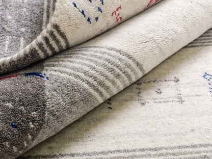 Moderner, Handloom Lori Gabbeh Orientteppich von Khademi aus Wolle mit Bambusseide, cremeweiß, grau, blau, rot. Nomaden-Design. Produziert in Indien. Größe: 239x168cm. Teppichnummer: KB4-1806. Verkauf durch Jupiter Intl.