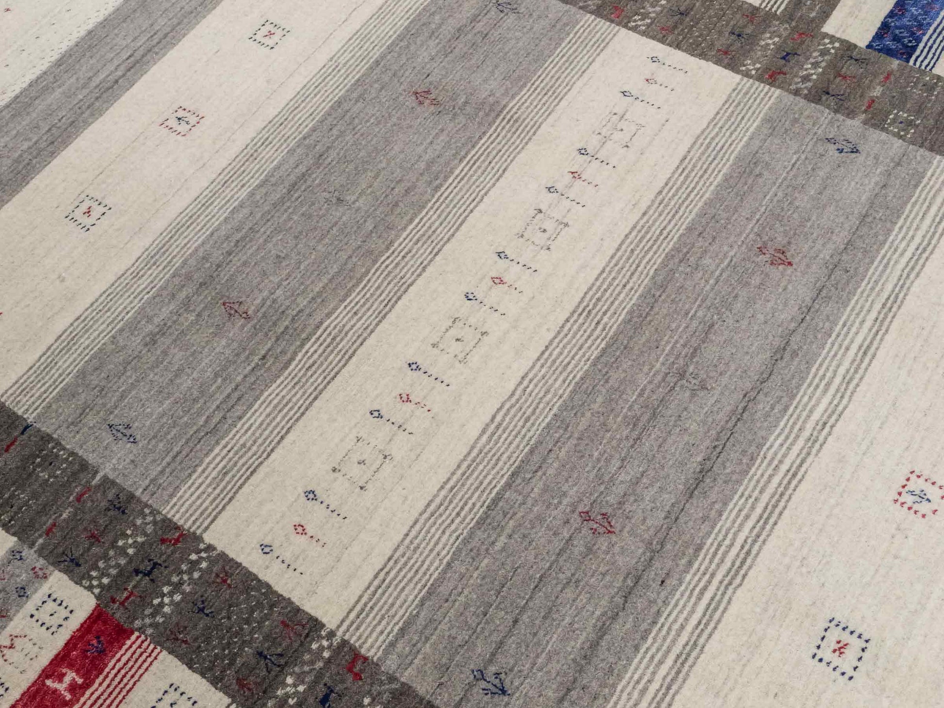 Moderner, Handloom Lori Gabbeh Orientteppich von Khademi aus Wolle mit Bambusseide, cremeweiß, grau, blau, rot. Nomaden-Design. Produziert in Indien. Größe: 239x168cm. Teppichnummer: KB4-1806. Verkauf durch Jupiter Intl.