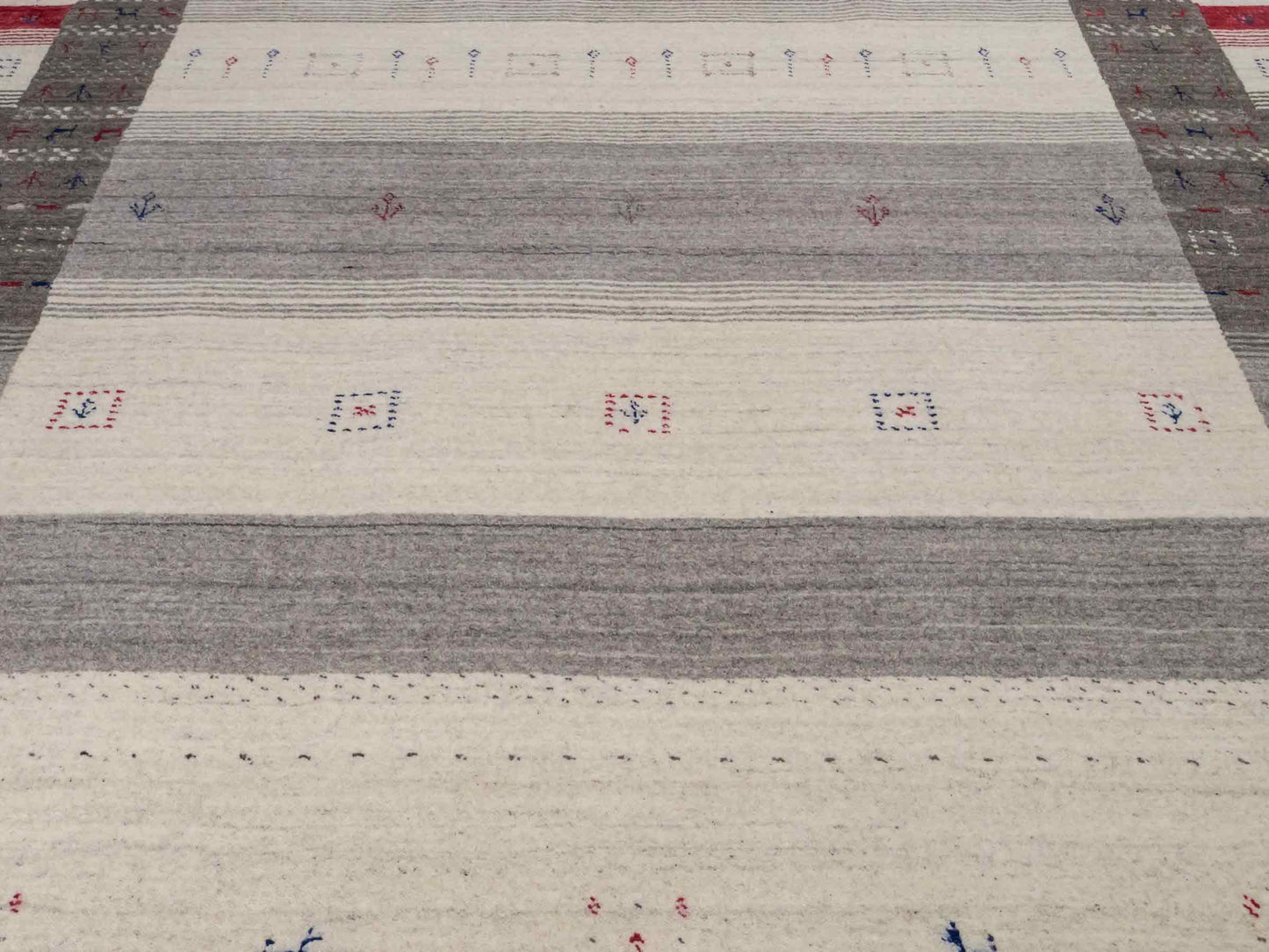 Moderner, Handloom Lori Gabbeh Orientteppich von Khademi aus Wolle mit Bambusseide, cremeweiß, grau, blau, rot. Nomaden-Design. Produziert in Indien. Größe: 239x168cm. Teppichnummer: KB4-1806. Verkauf durch Jupiter Intl.