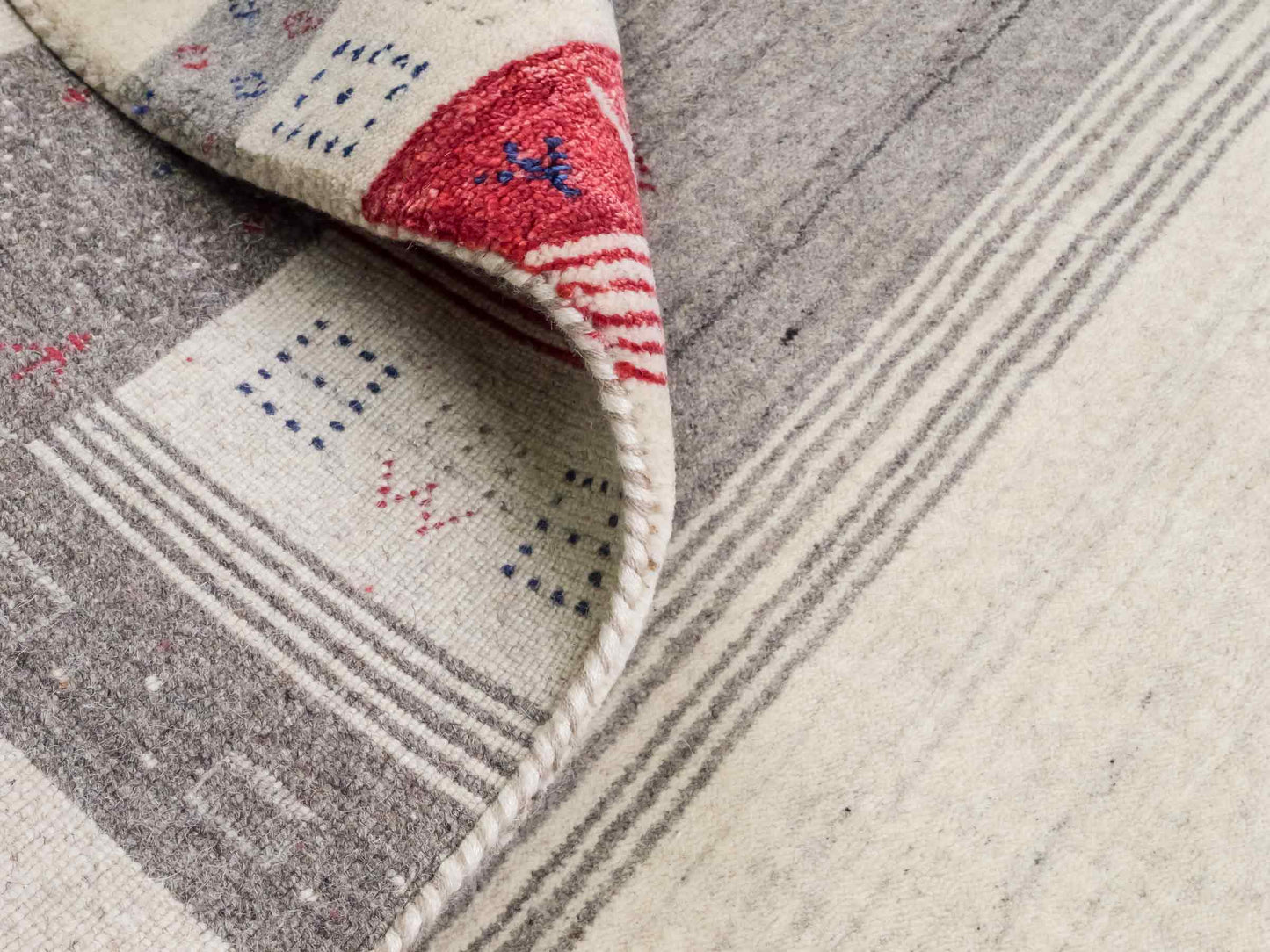 Moderner, Handloom Lori Gabbeh Orientteppich von Khademi aus Wolle mit Bambusseide, cremeweiß, grau, blau, rot. Nomaden-Design. Produziert in Indien. Größe: 239x168cm. Teppichnummer: KB4-1806. Verkauf durch Jupiter Intl.