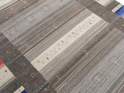 Moderner, Handloom Lori Gabbeh Orientteppich von Khademi aus Wolle mit Bambusseide, cremeweiß, grau, mehrfarbig. Nomaden-Design. Produziert in Indien. Größe: 239x173cm. Teppichnummer: KB4-1804. Verkauf durch Jupiter Intl.