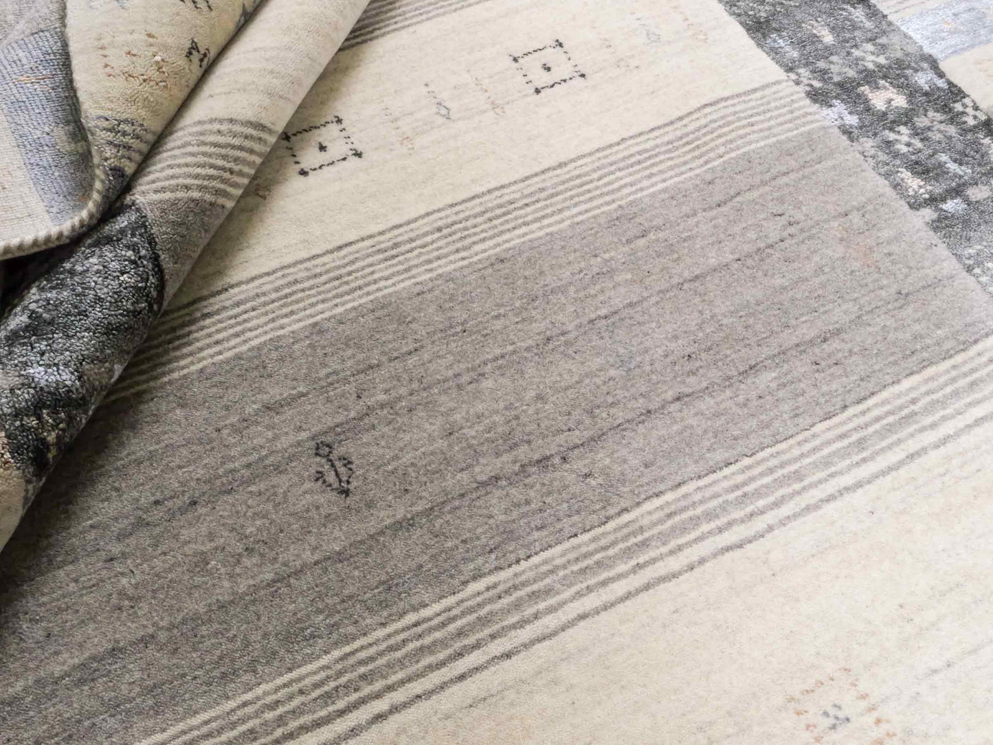 Moderner, Handloom Lori Gabbeh Orientteppich von Khademi aus Wolle mit Bambusseide, cremeweiß, grau, blau, braun. Nomaden-Design. Produziert in Indien. Größe: 241x172cm. Teppichnummer: KB4-1805. Verkauf durch Jupiter Intl.