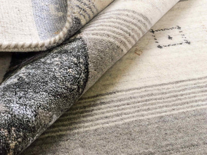 Moderner, Handloom Lori Gabbeh Orientteppich von Khademi aus Wolle mit Bambusseide, cremeweiß, grau, blau, braun. Nomaden-Design. Produziert in Indien. Größe: 241x172cm. Teppichnummer: KB4-1805. Verkauf durch Jupiter Intl.