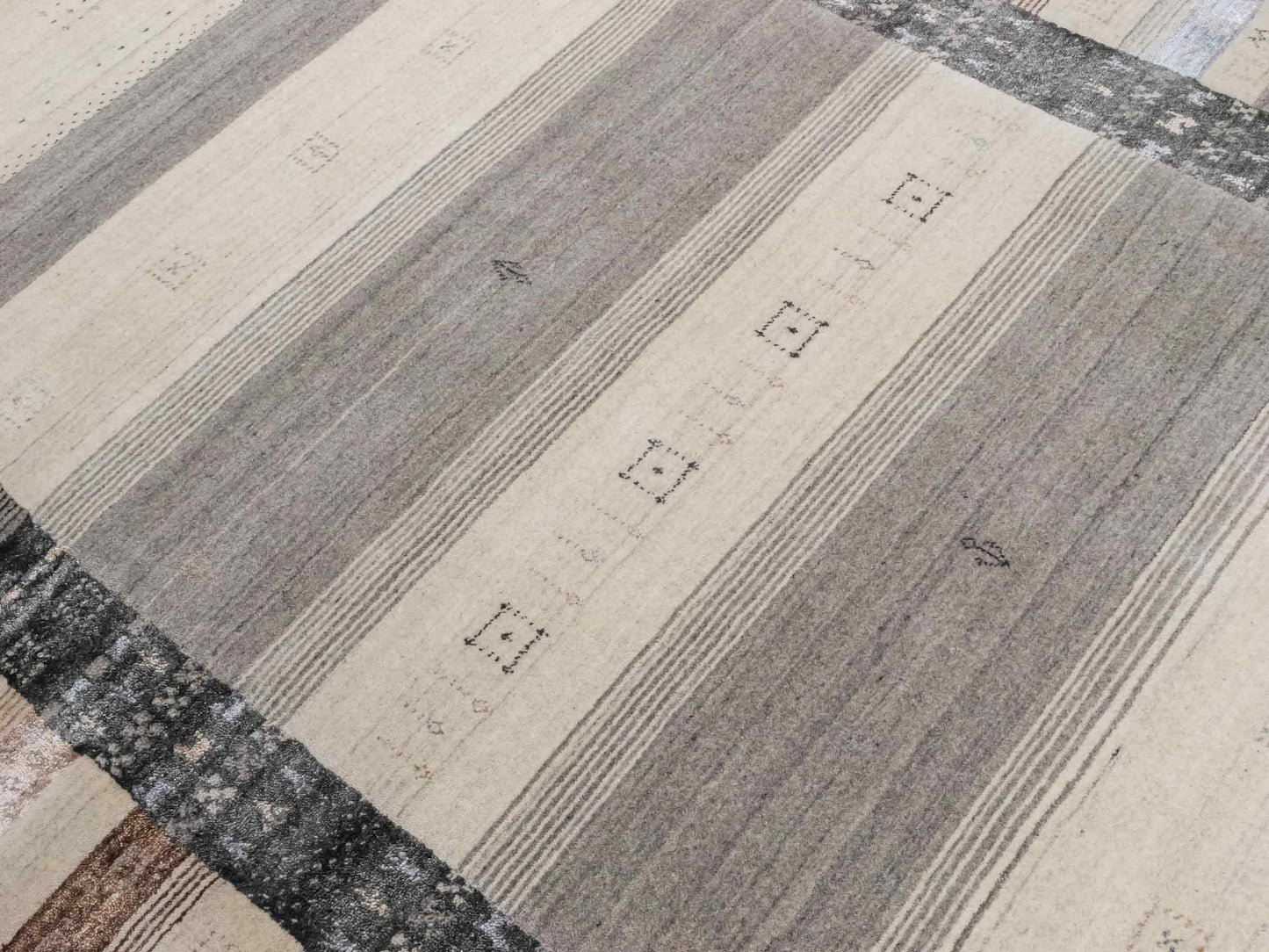 Moderner, Handloom Lori Gabbeh Orientteppich von Khademi aus Wolle mit Bambusseide, cremeweiß, grau, blau, braun. Nomaden-Design. Produziert in Indien. Größe: 241x172cm. Teppichnummer: KB4-1805. Verkauf durch Jupiter Intl.