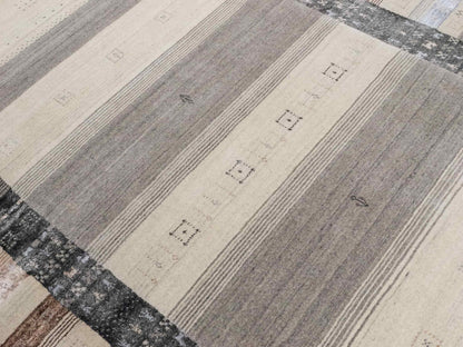 Moderner, Handloom Lori Gabbeh Orientteppich von Khademi aus Wolle mit Bambusseide, cremeweiß, grau, blau, braun. Nomaden-Design. Produziert in Indien. Größe: 241x172cm. Teppichnummer: KB4-1805. Verkauf durch Jupiter Intl.