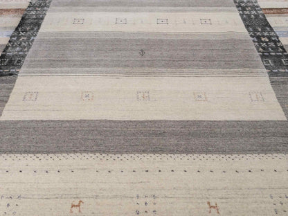 Moderner, Handloom Lori Gabbeh Orientteppich von Khademi aus Wolle mit Bambusseide, cremeweiß, grau, blau, braun. Nomaden-Design. Produziert in Indien. Größe: 241x172cm. Teppichnummer: KB4-1805. Verkauf durch Jupiter Intl.