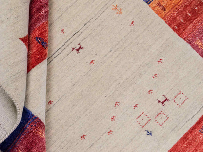 Moderner, Handloom Lori Gabbeh Orientteppich von Khademi aus Wolle mit Bambusseide, cremeweiß, beige, rot. Nomaden-Design. Produziert in Indien. Größe: 241x175cm. Teppichnummer: KB4-1821. Verkauf durch Jupiter Intl.