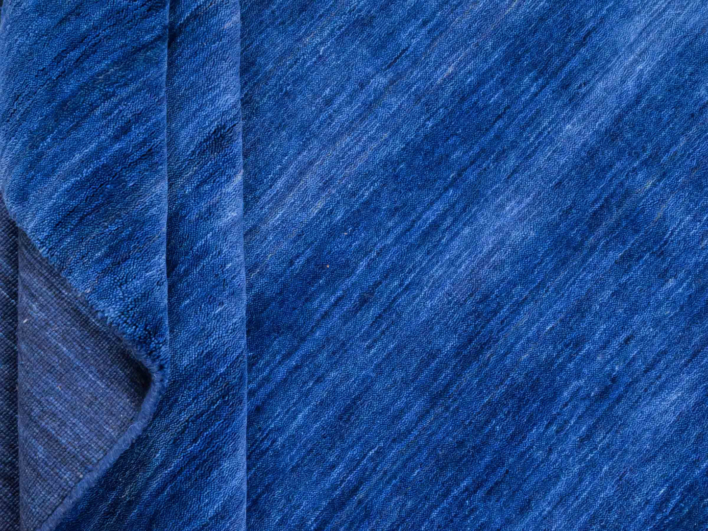 Moderner, Handloom Gabbeh Orientteppich von Khademi aus Wolle, blau. Einfarbiges Uni-Design. Produziert in Indien. Größe: 198x140cm. Teppichnummer: KB4-1590. Verkauf durch Jupiter Intl.