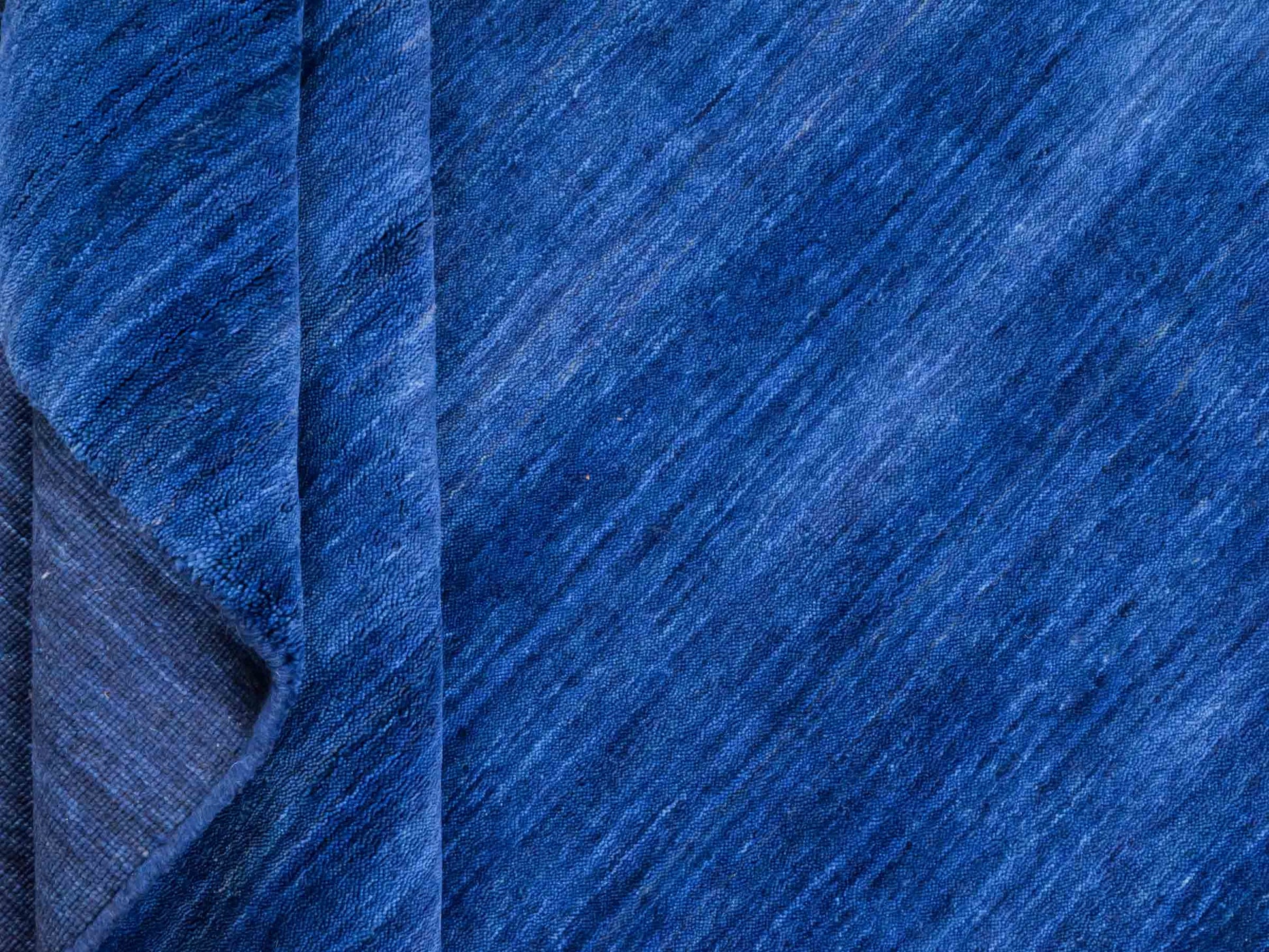 Moderner, Handloom Gabbeh Orientteppich von Khademi aus Wolle, blau. Einfarbiges Uni-Design. Produziert in Indien. Größe: 198x140cm. Teppichnummer: KB4-1590. Verkauf durch Jupiter Intl.