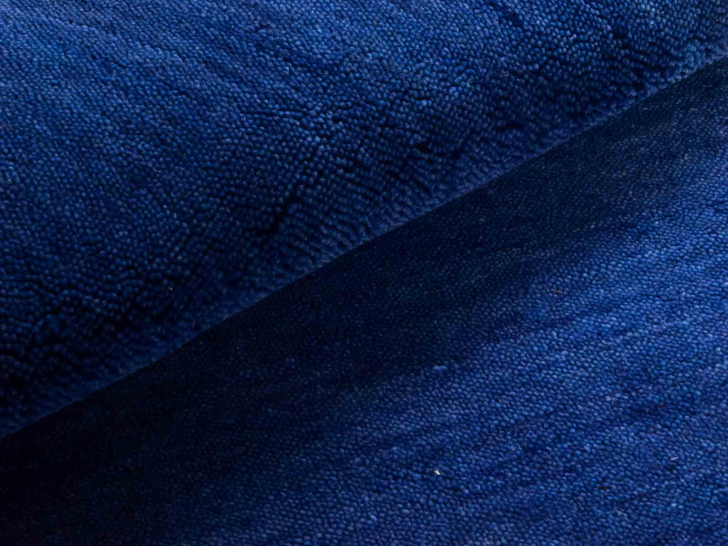 Moderner, Handloom Gabbeh Orientteppich von Khademi aus Wolle, blau. Einfarbiges Uni-Design. Produziert in Indien. Größe: 86x59cm. Teppichnummer: KB4-1592. Verkauf durch Jupiter Intl.