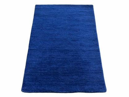 Moderner, Handloom Gabbeh Orientteppich von Khademi aus Wolle, blau. Einfarbiges Uni-Design. Produziert in Indien. Größe: 86x59cm. Teppichnummer: KB4-1592. Verkauf durch Jupiter Intl.