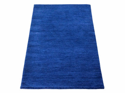 Moderner, Handloom Gabbeh Orientteppich von Khademi aus Wolle, blau. Einfarbiges Uni-Design. Produziert in Indien. Größe: 86x59cm. Teppichnummer: KB4-1592. Verkauf durch Jupiter Intl.