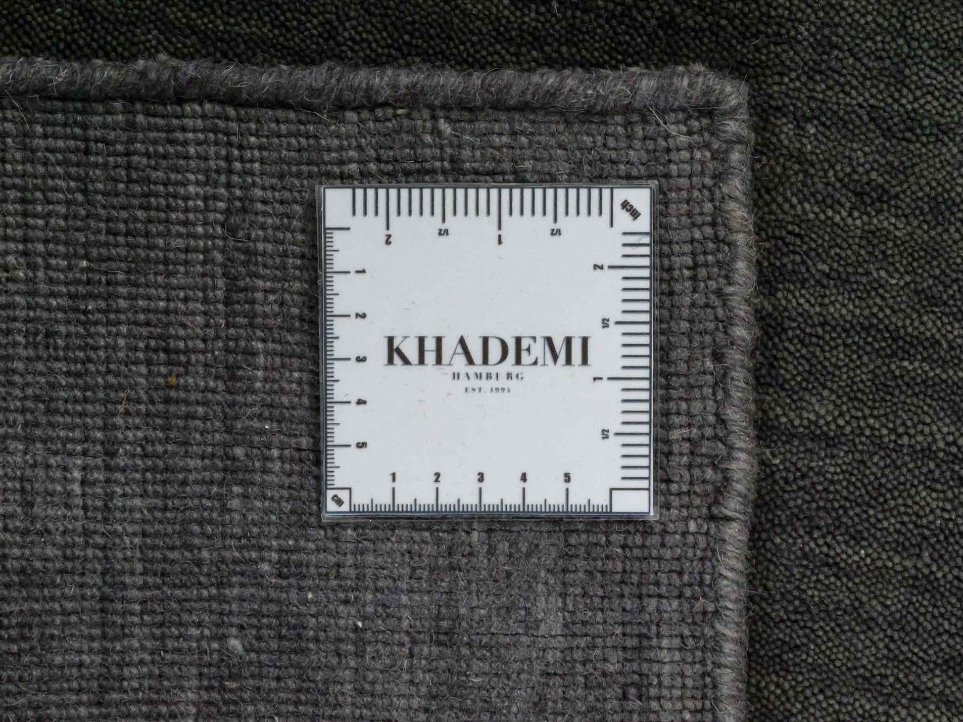 Moderner, Handloom Gabbeh Orientteppich von Khademi aus Wolle, grau. Einfarbiges Uni-Design. Produziert in Indien. Größe: 88x60cm. Teppichnummer: KB4-1610. Verkauf durch Jupiter Intl.