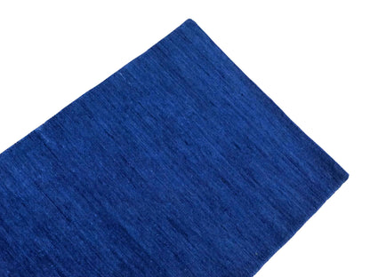 Moderner, Handloom Gabbeh Orientteppich von Khademi aus Wolle, blau. Einfarbiges Uni-Design. Produziert in Indien. Größe: 89x59cm. Teppichnummer: KB4-1593. Verkauf durch Jupiter Intl.