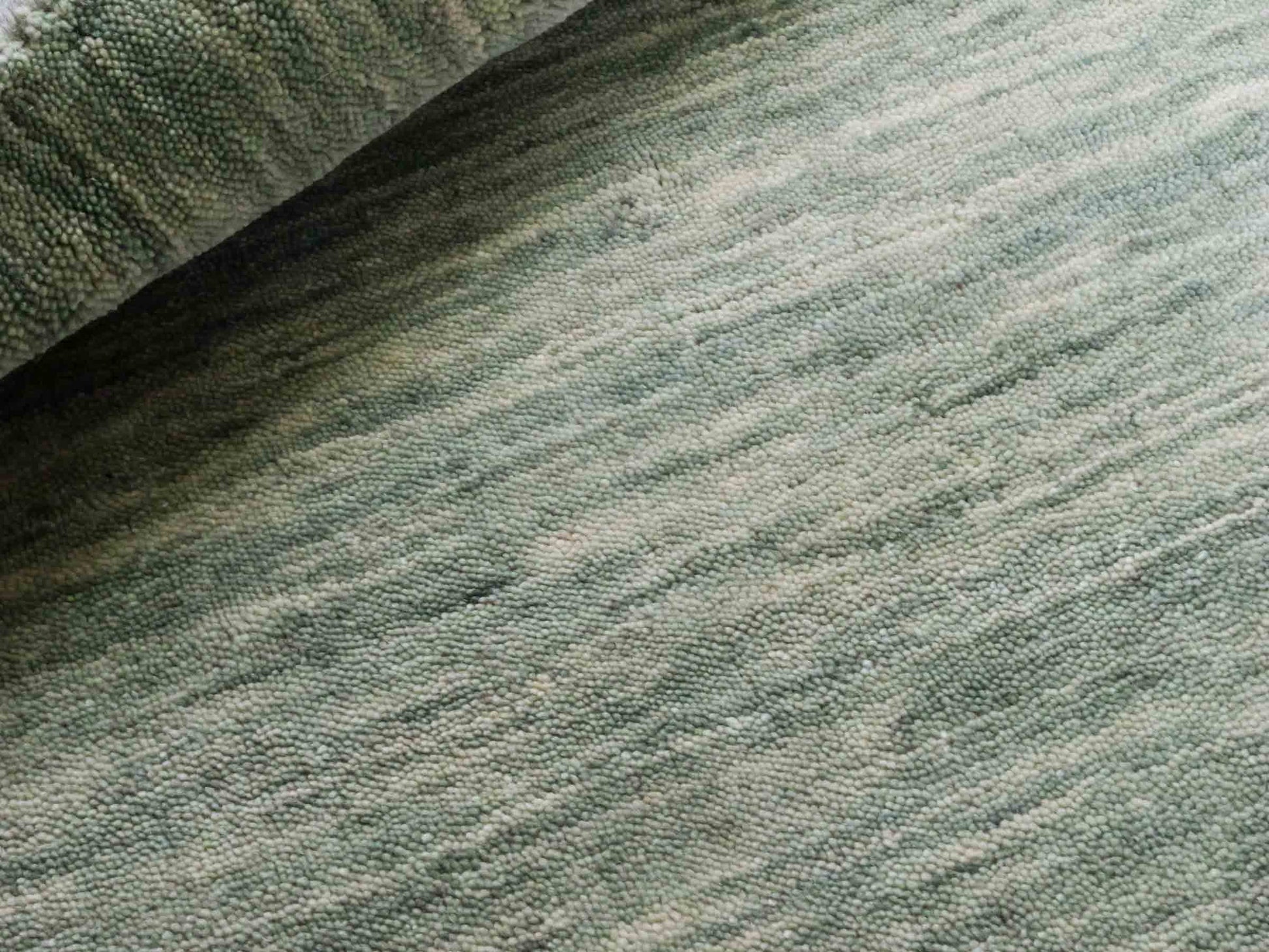 Moderner, Handloom Gabbeh Orientteppich von Khademi aus Wolle, mintgrün. Einfarbiges Uni-Design. Produziert in Indien. Größe: 92x58cm. Teppichnummer: KB4-1566. Verkauf durch Jupiter Intl.