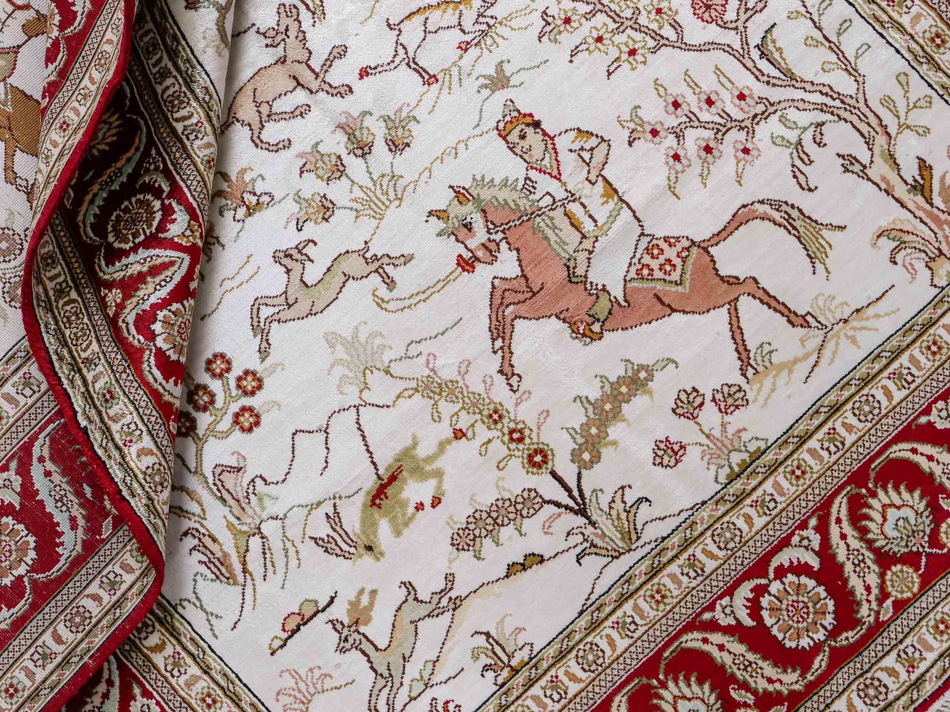 Feiner, handgeknüpfter Art Ghom aus Kunstseide. Ursprung China. Größe: 183 x 123 cm. Hauptfarben: Weiß, Creme, Rot. Vertrieb durch JUPITER Intl.