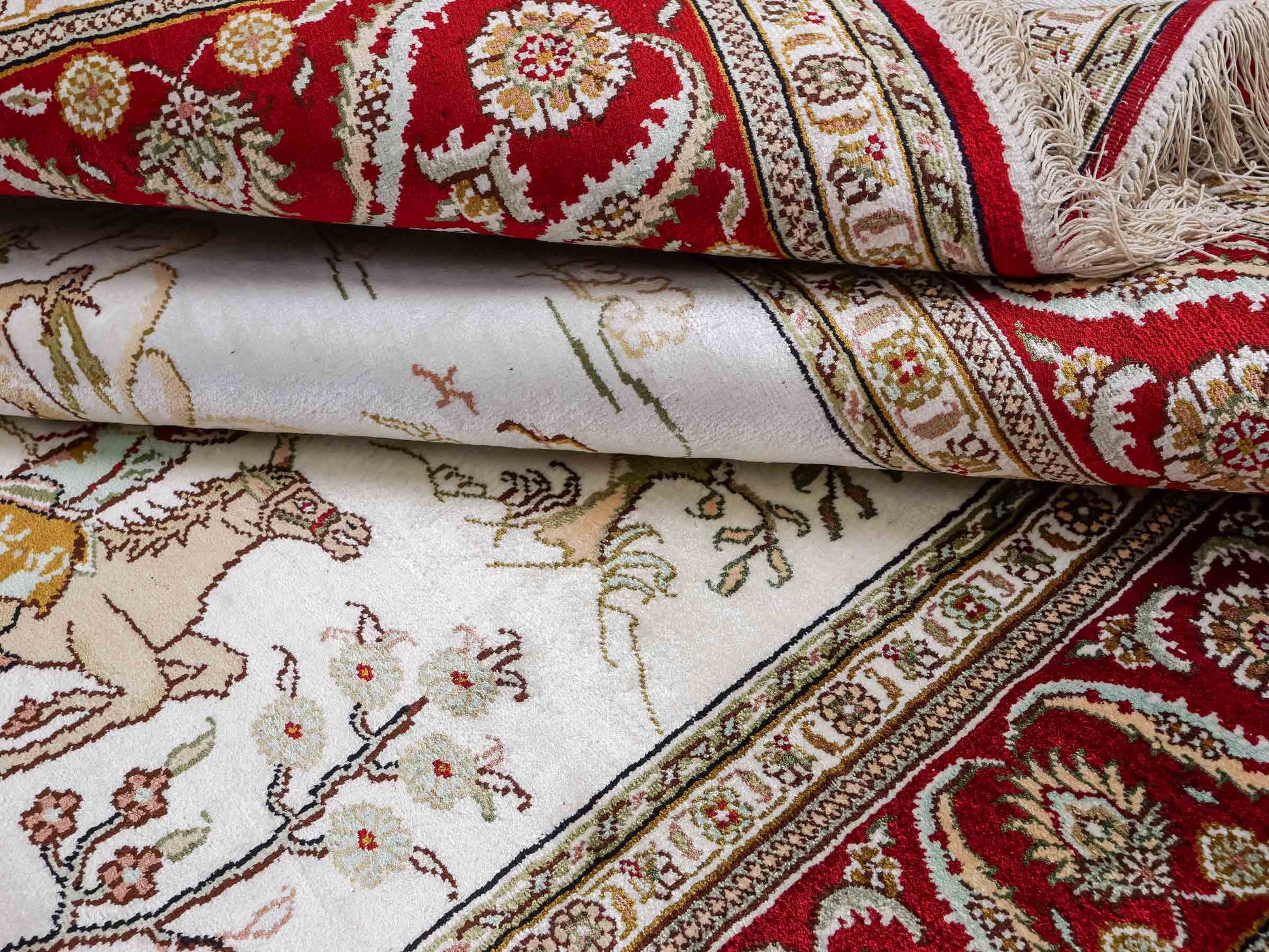 Feiner, handgeknüpfter Art Ghom aus Kunstseide. Ursprung China. Größe: 183 x 123 cm. Hauptfarben: Weiß, Creme, Rot. Vertrieb durch JUPITER Intl.