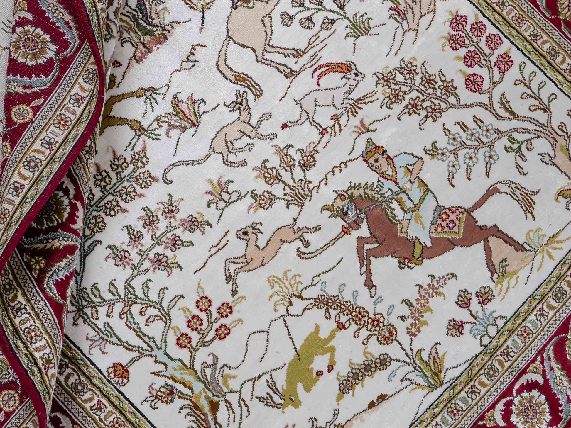 Feiner, handgeknüpfter Art Ghom aus Kunstseide. Ursprung China. Größe: 193 x 121 cm. Hauptfarben: Weiß, Creme, Rot. Vertrieb durch JUPITER Intl.