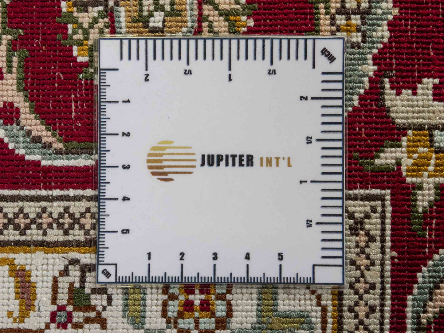 Feiner, handgeknüpfter Art Ghom aus Kunstseide. Ursprung China. Größe: 193 x 121 cm. Hauptfarben: Weiß, Creme, Rot. Vertrieb durch JUPITER Intl.