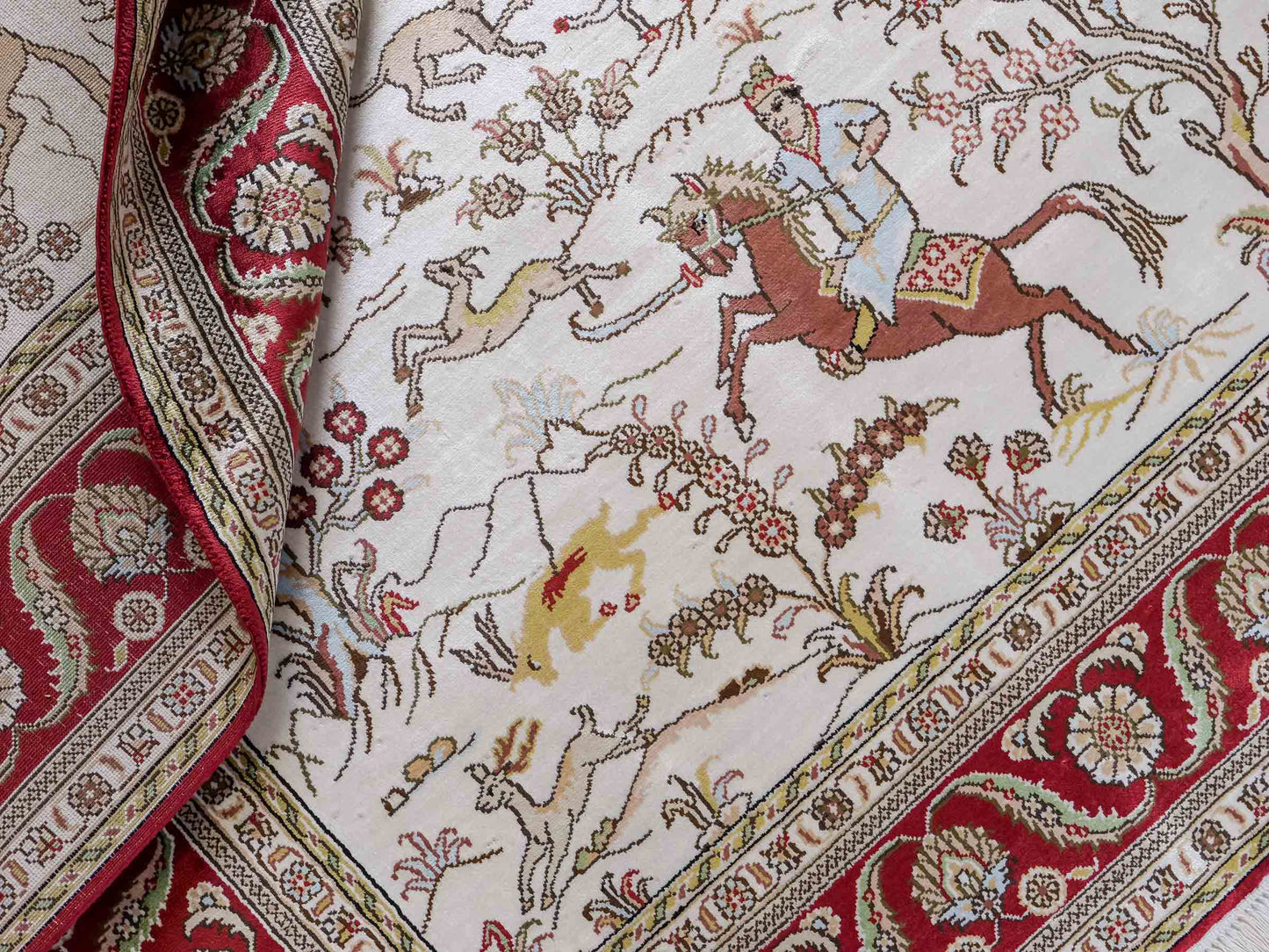 Feiner, handgeknüpfter Art Ghom aus Kunstseide. Ursprung China. Größe: 181 x 125 cm. Hauptfarben: Weiß, Creme, Rot. Vertrieb durch JUPITER Intl.