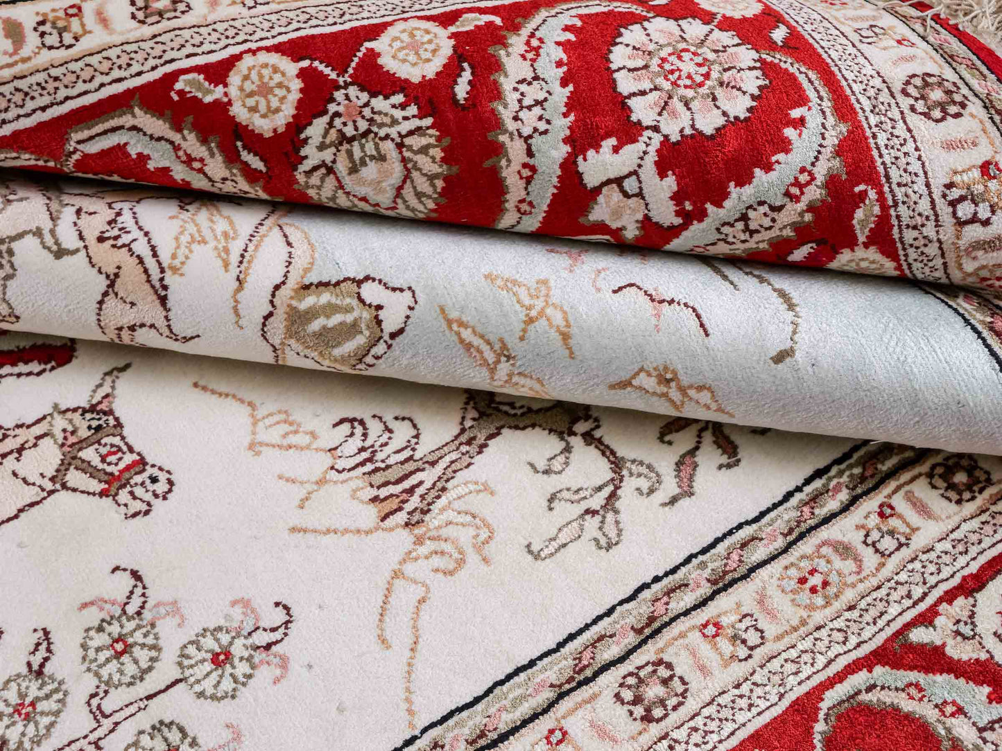 Feiner, handgeknüpfter Art Ghom aus Kunstseide. Ursprung China. Größe: 183 x 123 cm. Hauptfarben: Weiß, Creme, Rot. Vertrieb durch JUPITER Intl.