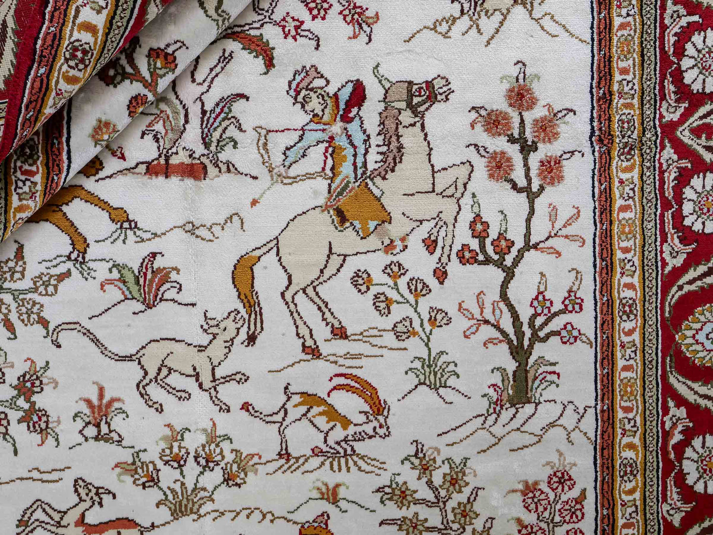 Feiner, handgeknüpfter Art Ghom aus Kunstseide. Ursprung China. Größe: 184 x 120 cm. Hauptfarben: Weiß, Creme, Rot. Vertrieb durch JUPITER Intl.