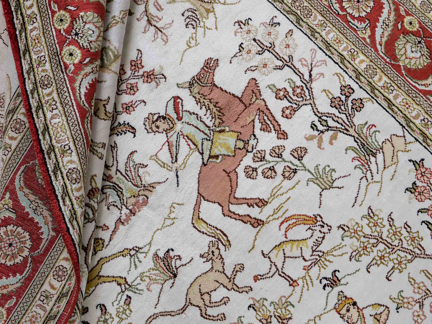 Feiner, handgeknüpfter Art Ghom aus Kunstseide. Ursprung China. Größe: 184 x 123 cm. Hauptfarben: Weiß, Creme, Rot. Vertrieb durch JUPITER Intl.