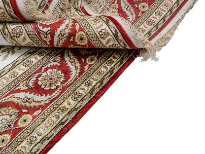 Feiner, handgeknüpfter Art Ghom aus Kunstseide. Ursprung China. Größe: 184 x 123 cm. Hauptfarben: Weiß, Creme, Rot. Vertrieb durch JUPITER Intl.