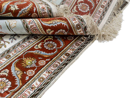 Feiner, handgeknüpfter Art Ghom aus Kunstseide. Ursprung China. Größe: 184 x 125 cm. Hauptfarben: Weiß, Creme, Rot. Vertrieb durch JUPITER Intl.